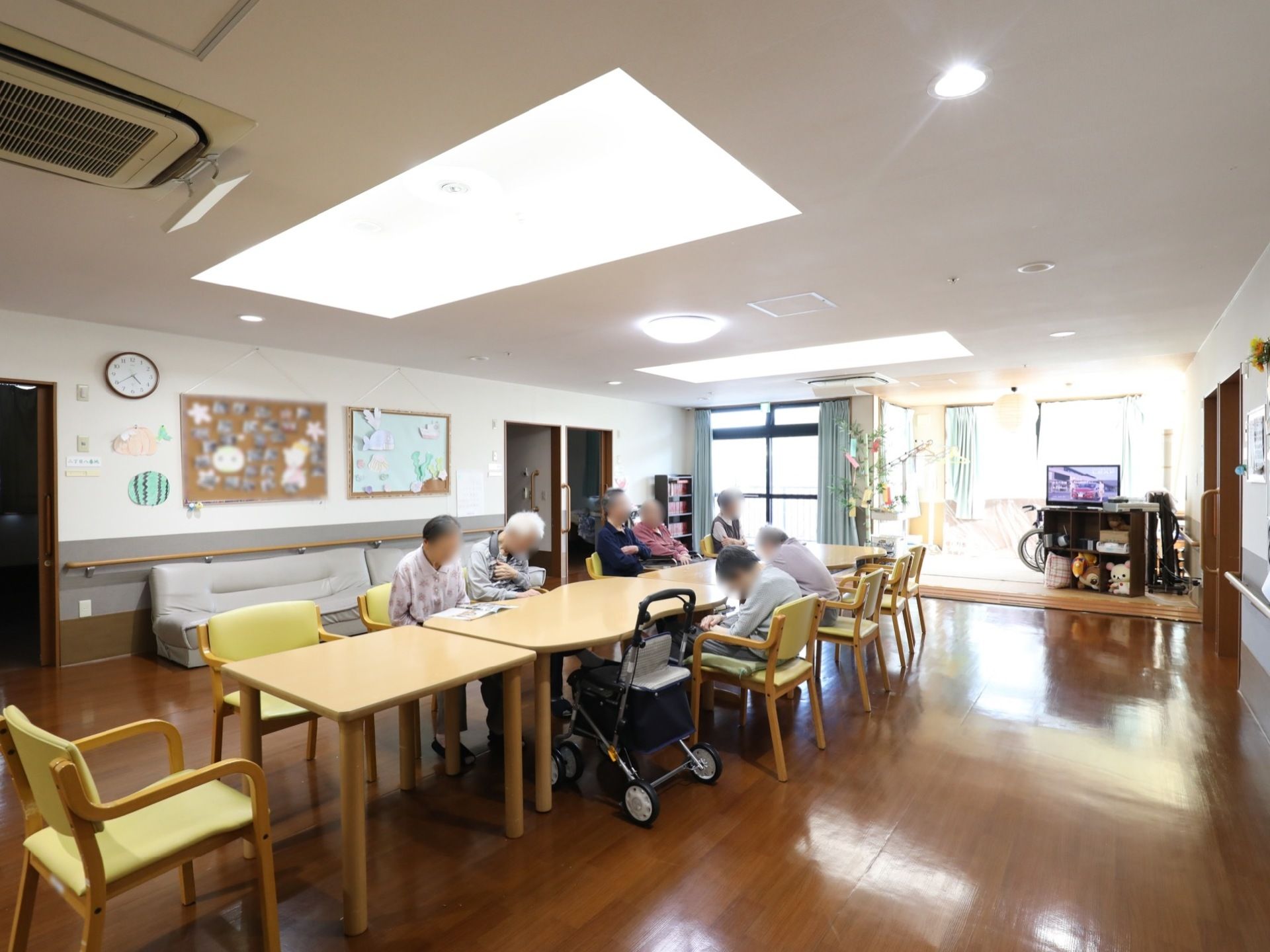 入居者様がそれぞれうたた寝したり本を読んだり、思い思いの時間を過ごしている。壁沿いにソファーが置かれている。