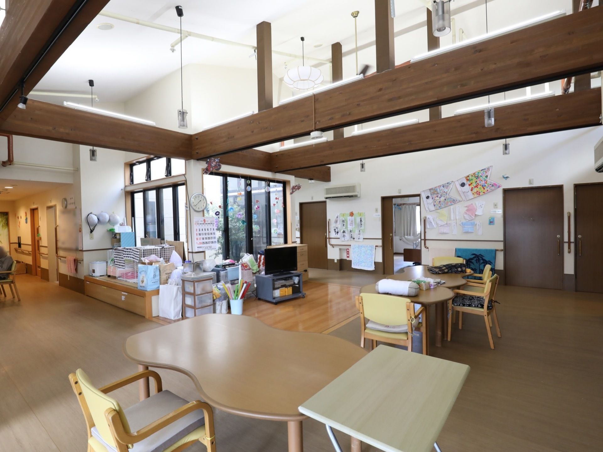 リビングルームは天井が高く、梁が下りてきているデザインである。テレビの前にテーブルセットが置かれている。