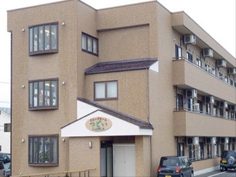 茶色い外壁を基調とした外観で、3階建てをした施設の建物