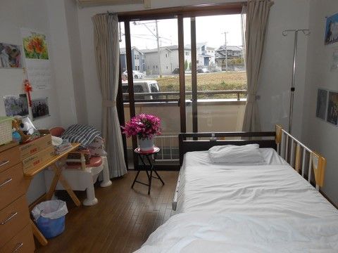 壁にポスターや写真が飾られている。部屋には花が置かれていて、大きな窓からは街の景観を眺めることができる。