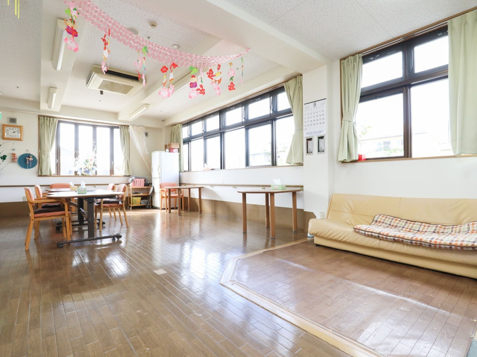 部屋の壁半分が窓で外光が入ってくるため、とても明るい室内である。テーブルや椅子、ソファーがあり、部屋の至る所に飾りつけがなされている。