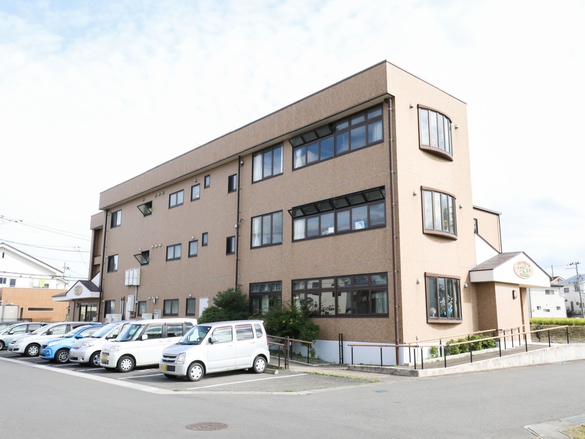 施設建物はレンガ調の３階建てで、見た目は近代的なマンションのようである。駐車スペースやスロープも完備している。