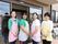 玄関ドアの前にスタッフの女性が４人並んでいる。全員動きやすいズボンとＴシャツやブラウス姿にエプロンをつけ、微笑んでいる。
