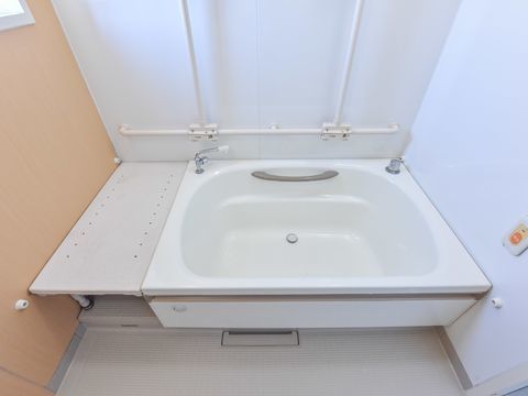 バスタブ脇には湯船と同じ高さの台が設置されており、物を置くなどして利用することができる。また壁には呼び出しベルが設置されている。