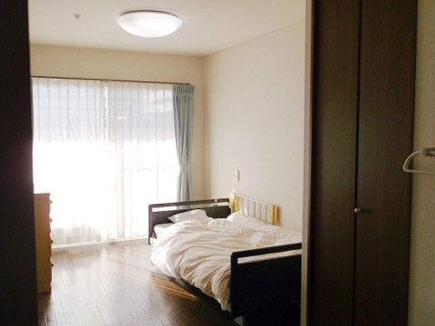 床面にはフローリングが敷かれており、大きな窓から入る日の光を反射している。窓には落ち着いた色合いのカーテンが留められている。