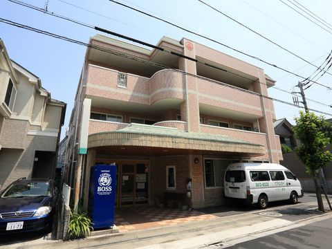 建物は3階建てで茶色っぽい色となっている。入り口には自動販売機が1台設置されている。2階と3階にはベランダが設けられている。