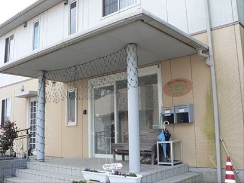 階段に、草花を植えているプランターを置いている玄関