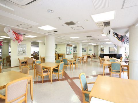 明るく開放感のある食堂には、ピンクとブルーの椅子がカラフルな洋風のテーブルセットが並ぶ。天井の季節飾りが楽しい空間を演出している。