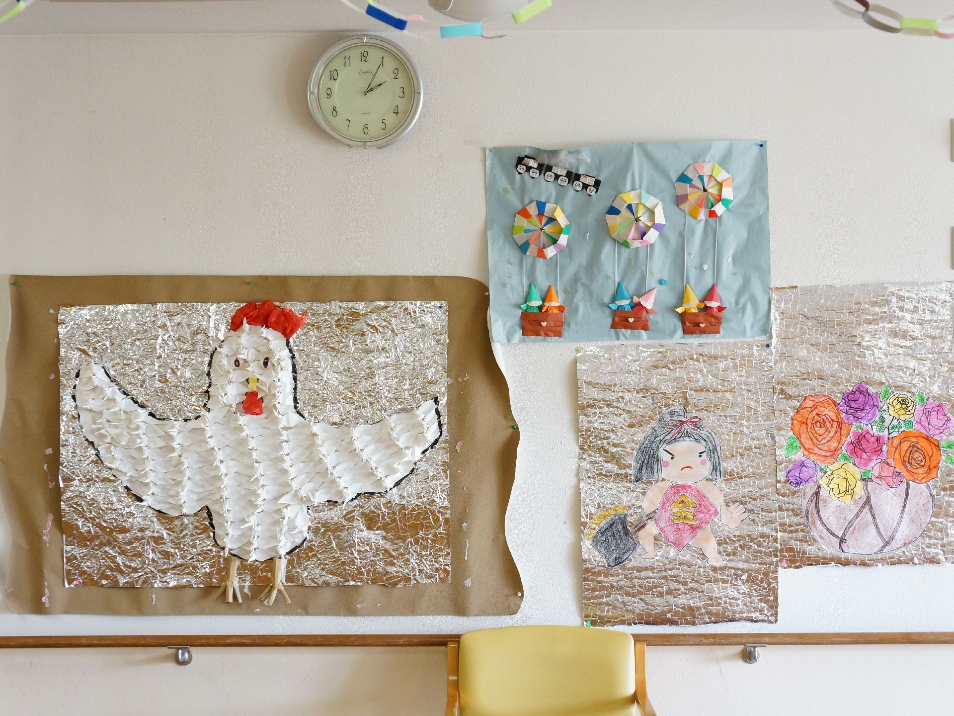 画用紙に折り紙で作った気球を貼り付けた立体的な作品や、アルミホイルに絵を貼り付けた作品が壁に掲示されている。