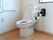 トイレは窓からの採光で明るく広々としている。立ち座りの動作を支える手すりを設置しており、壁には呼び出しボタンが付いている。