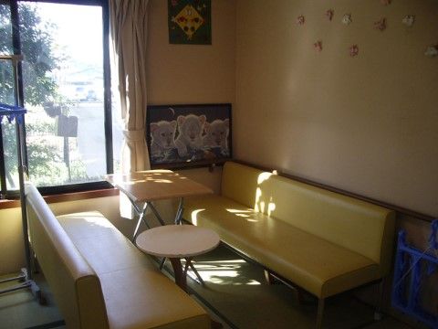 畳の上でくつろぐことも、ソファでゆったりとすることもできるスペースとなっている。壁にはいくつもの絵が飾られている。