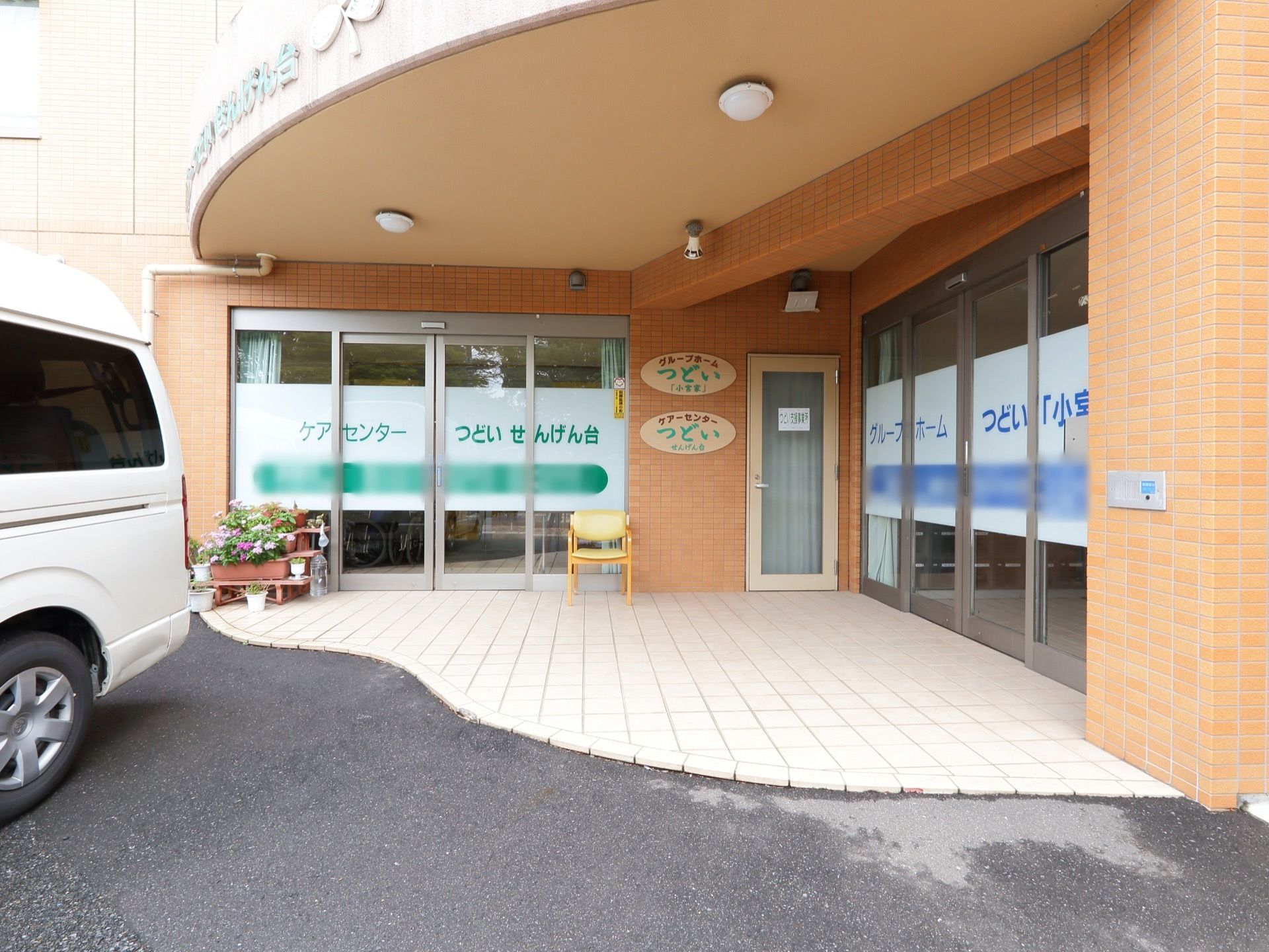 ケアホームとグループホームが並んでいる。屋根があり、雨の日も安心である。椅子が置かれている。車椅子の人も利用しやすい。