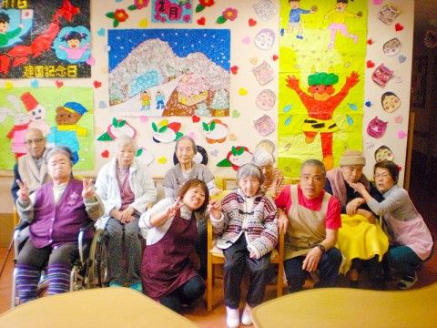 季節感ある装飾の前で、楽しそうに微笑むご入居者様とスタッフ