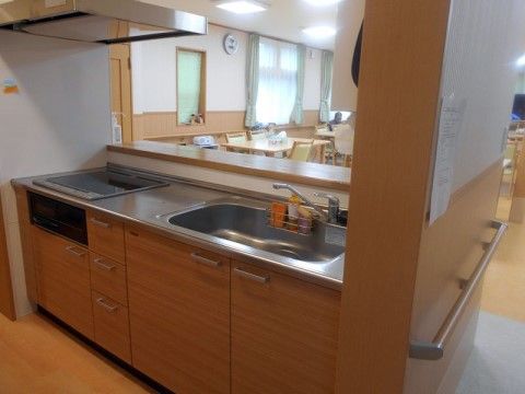 食堂には、ＩＨ式のコンロが搭載されたシステムキッチンがある。カウンターがあり、職員が調理をしながら入居者様の見守りが行える。