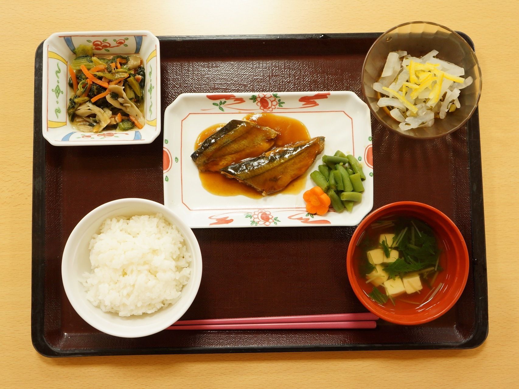 お盆の上に、５種類の食材がきちんと並べられている。真ん中に魚、左下、右下にはご飯とみそ汁、上の両側には小鉢が置かれている。