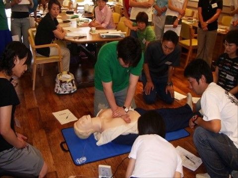 心臓マッサージを実際に経験する男性と見守るスタッフ