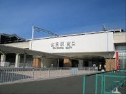 最寄り駅の電車を利用して施設に来訪することもできる。車道も歩道も広く、白のガードレールが設置されている。