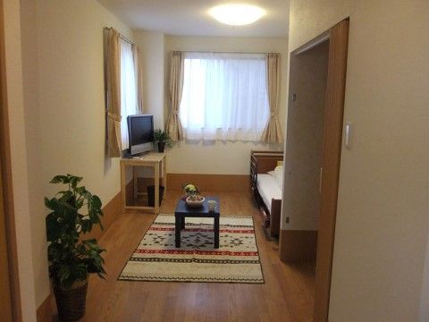 居室にはミニサイズのテーブルと共に赤色、黄色、緑色のカラフルな柄のじゅうたんが敷かれ落ち着いた雰囲気となっている。