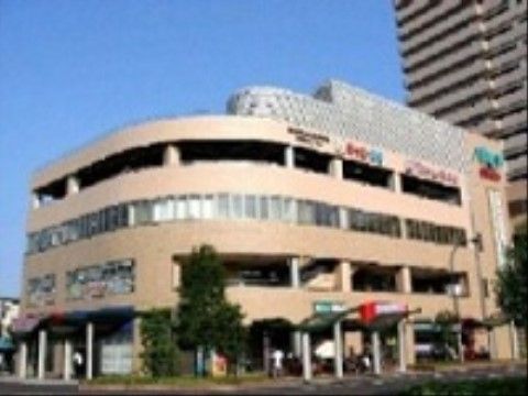 施設の近隣には淡いベージュ色の外観の商業施設が立地しており、食品や日用品などを買い揃えることができる。