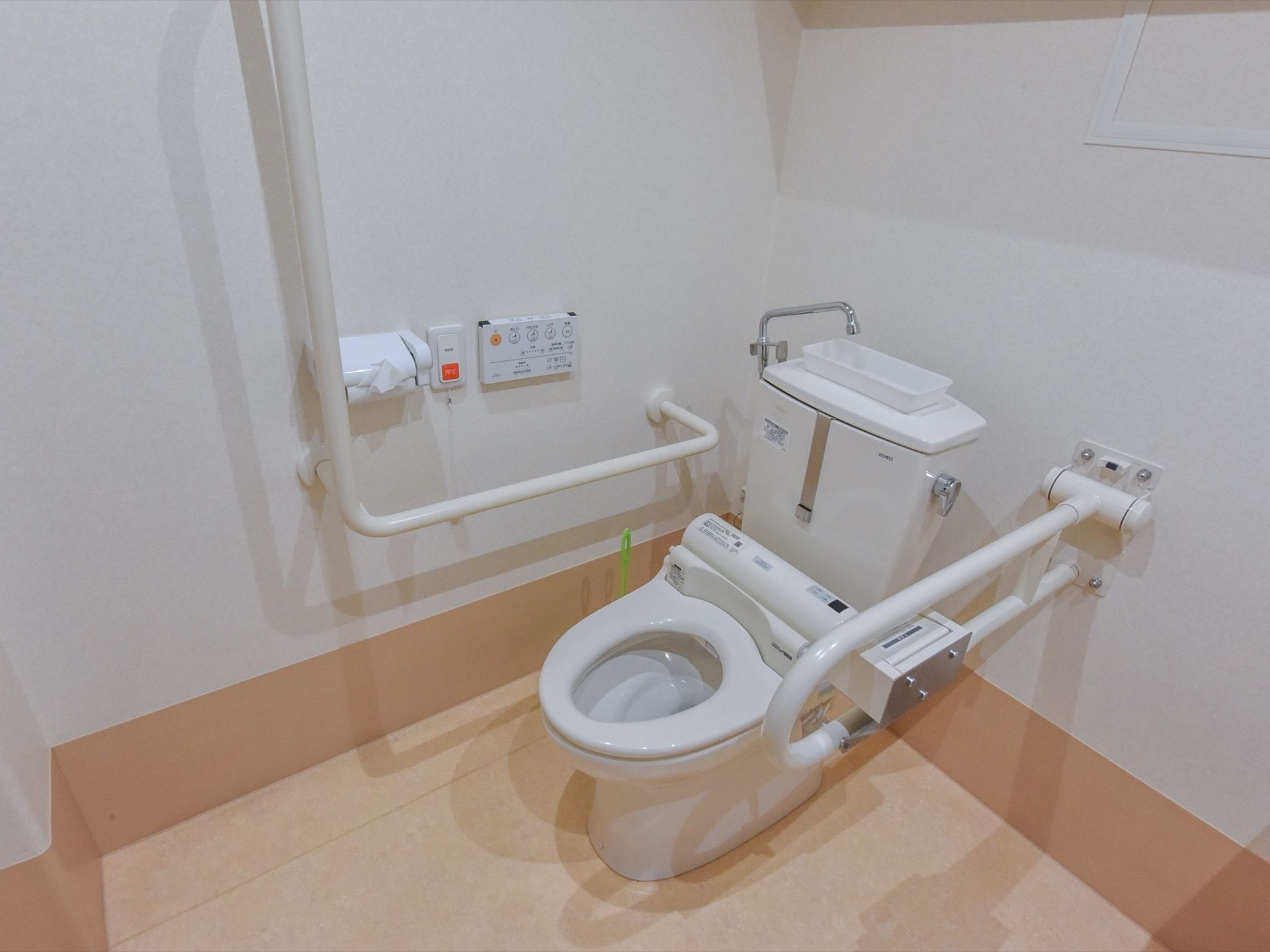 洋式トイレの両側には高齢者でも使いやすいように手すりを設置している。緊急時にスタッフを呼び出すナースコールも付いている。