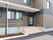 木造二階建ての建物の玄関部分。階段とスロープが設置してある。傘立てが置いてある。玄関には、AEDのシールが貼ってある。