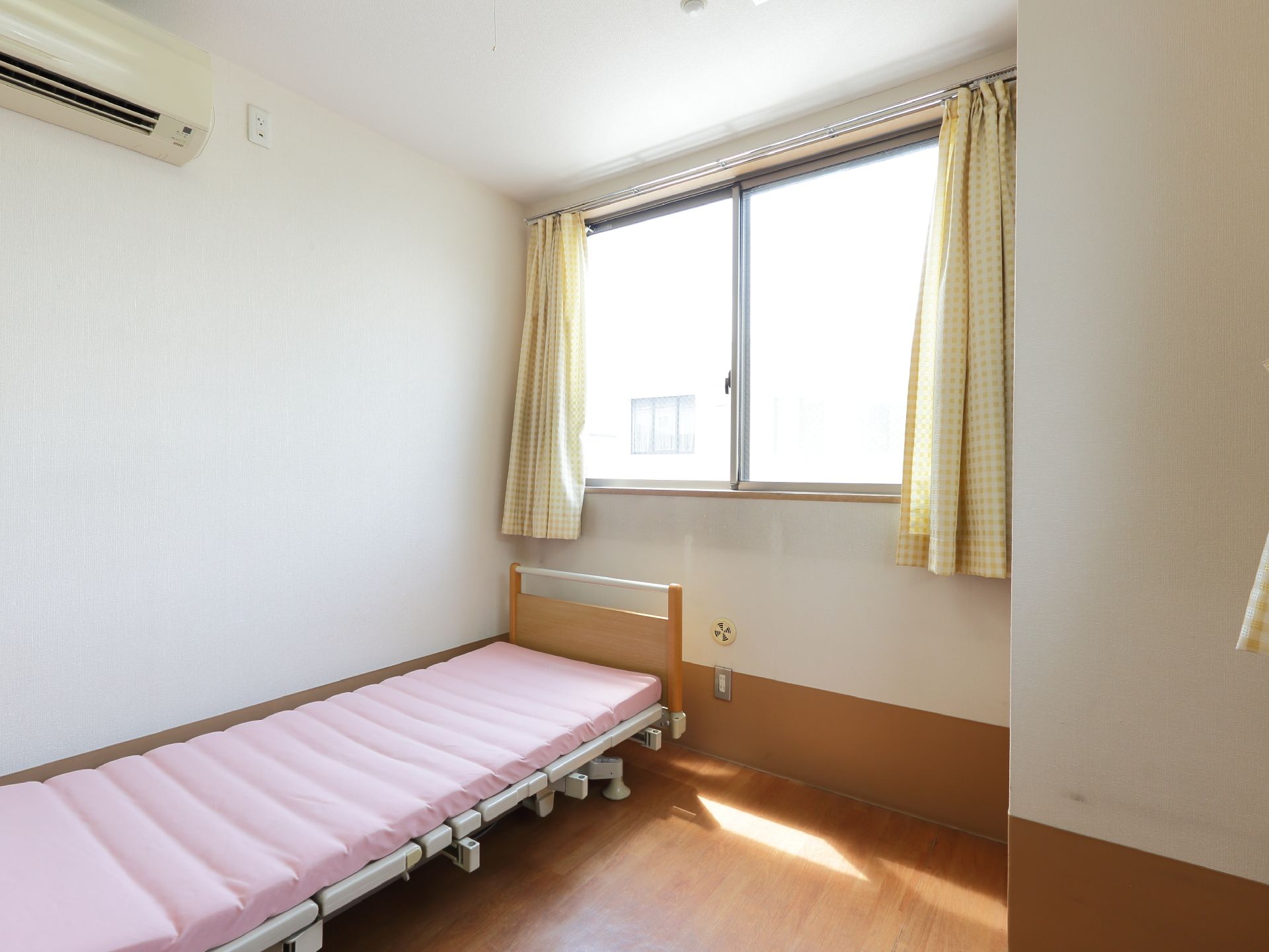 部屋は日が良く入る窓があり、換気も良好である。ピンク色のマットが敷かれているベッドがあり、カーテンも付いている。