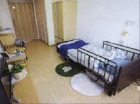 介護ベッドには転落防止用の柵が設けられており、壁には緊急時用のナースコールが付いている。家具を置いてもスペースに余裕がある。