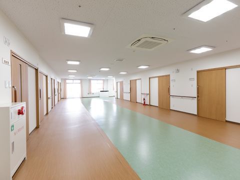 廊下フロアの突き当たりには日差しを取り込む窓が2つ設けられている。左右の壁際には非常用の押しボタンと消火器がある。