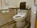 洋式トイレに背もたれや手すりが設置されている個室トイレ。
