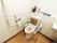 白い壁が明るい雰囲気のトイレである。隅々まで掃除が行き届いていて清潔に保たれている。大きな手すりもあり安心。