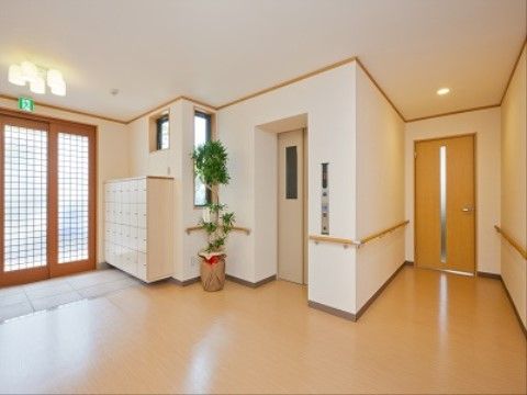 玄関ホールは広々としていて開放的でフロア全体はバリアフリーとなっており、上階に上がるエレベーターも玄関口すぐに設置されていて便利である。