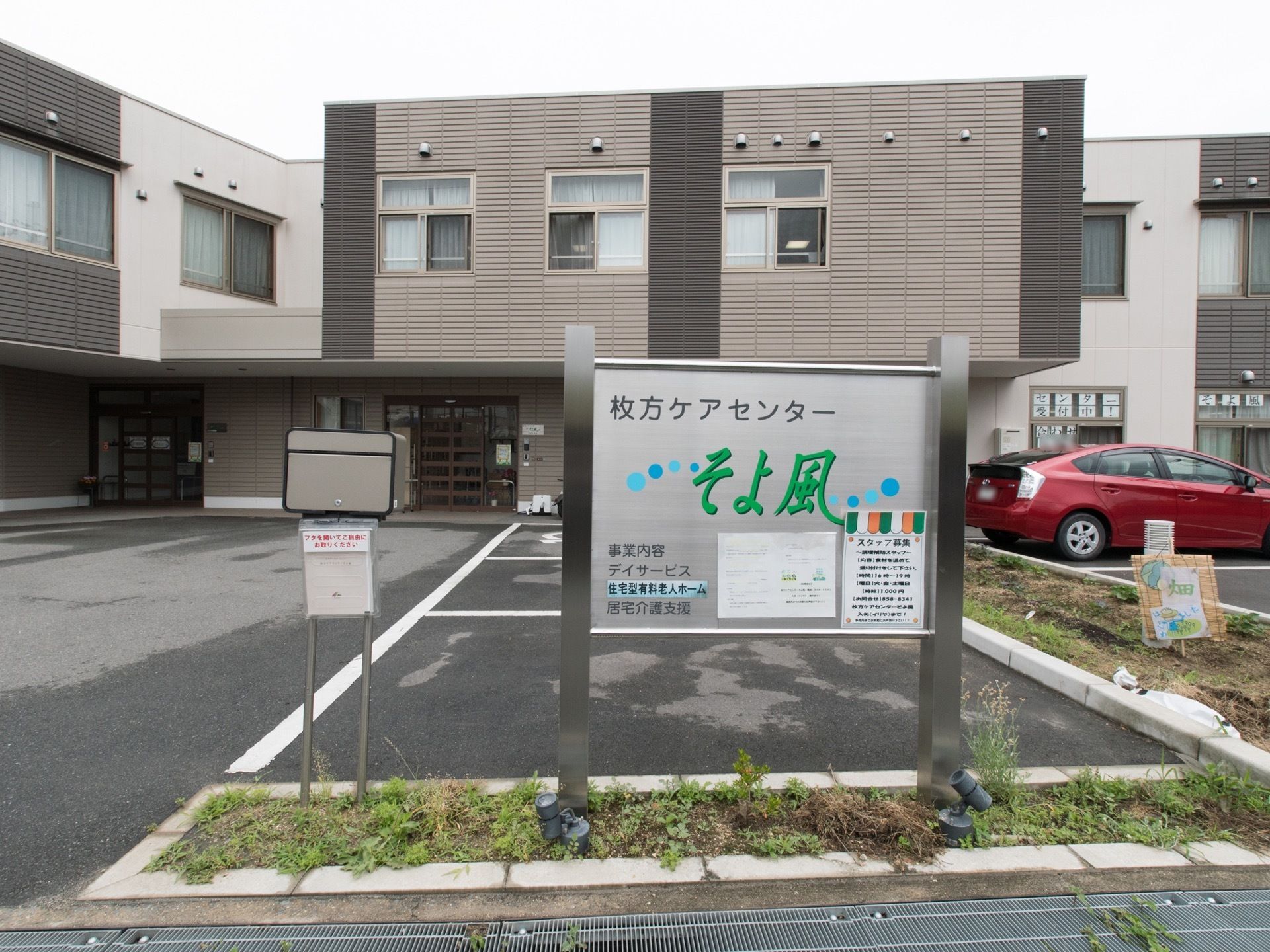 施設の前には駐車スペースがある。道路の通りから見えるように施設の種類と施設名が表示されている。夜にはライトアップされる。