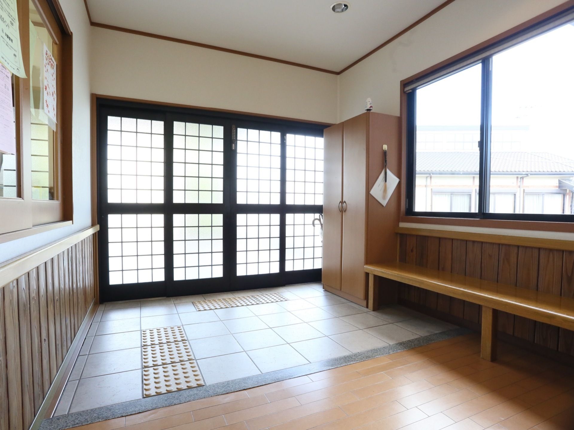 両開きの格子扉が設置されている玄関は、間口が広く開放的である。車椅子をご利用の方もスムーズに施設内へお入りいただける。