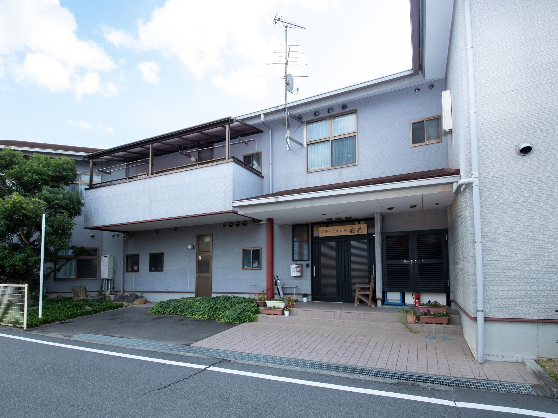 白を基調とした２階建ての建物である。エントランス前に２台分の駐車スペースと休憩用のベンチが完備されている。