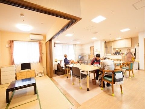右側のフローリングのスペースがあり、テーブルセットが置かれている。椅子の脚には滑り止めが取り付けられている。