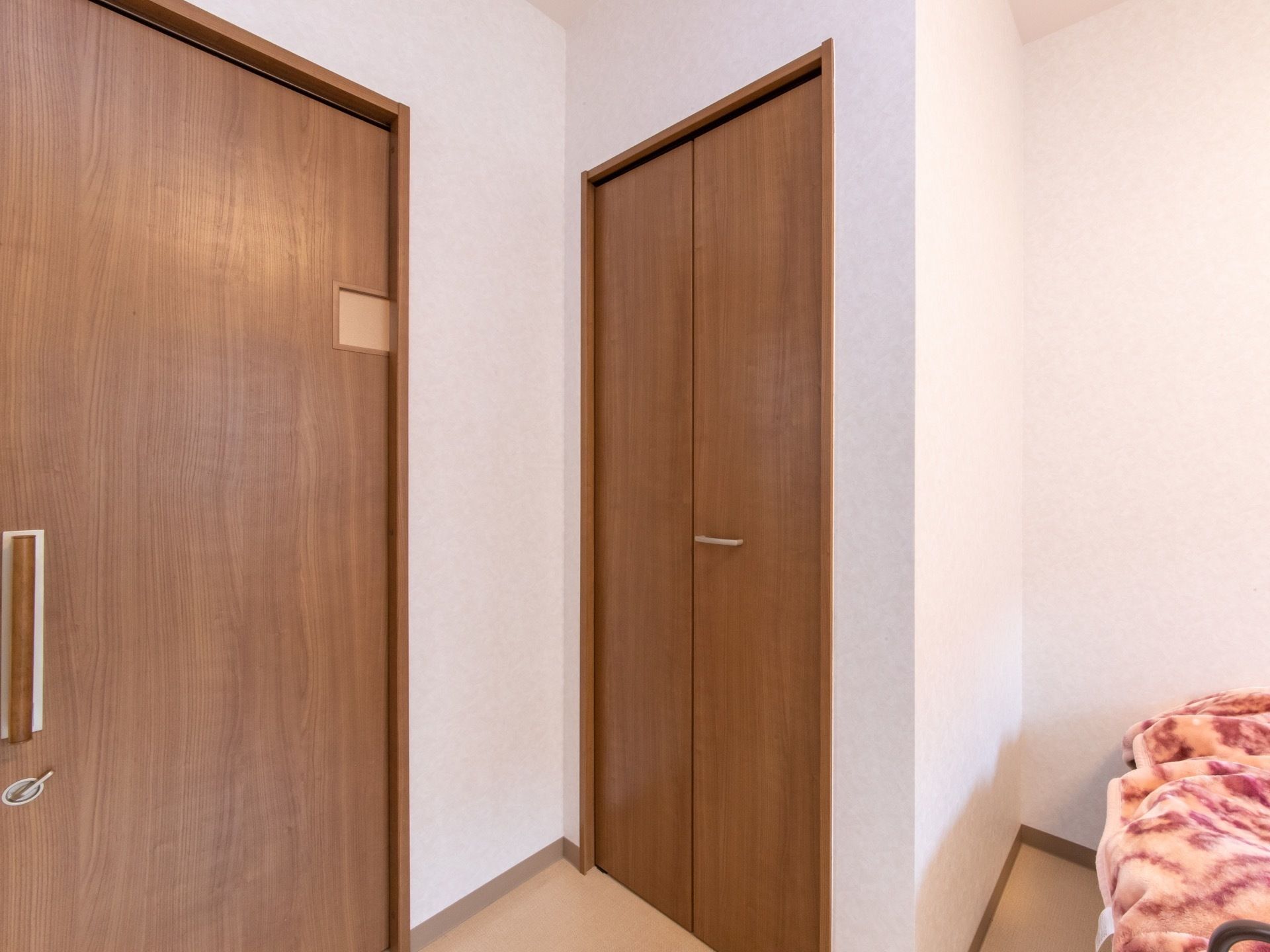 居室入口は幅が広い引き戸になっていて、中から鍵がかけられるようになっている。居室に入ってすぐの所に、折り戸タタイプの収納スペースがある。
