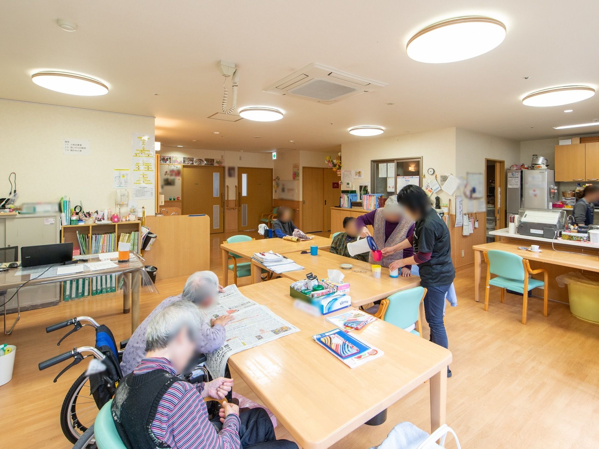 5人程の入居者様が過ごされており、新聞を読まれたりスタッフの手伝いをされたりしながら過ごされている。