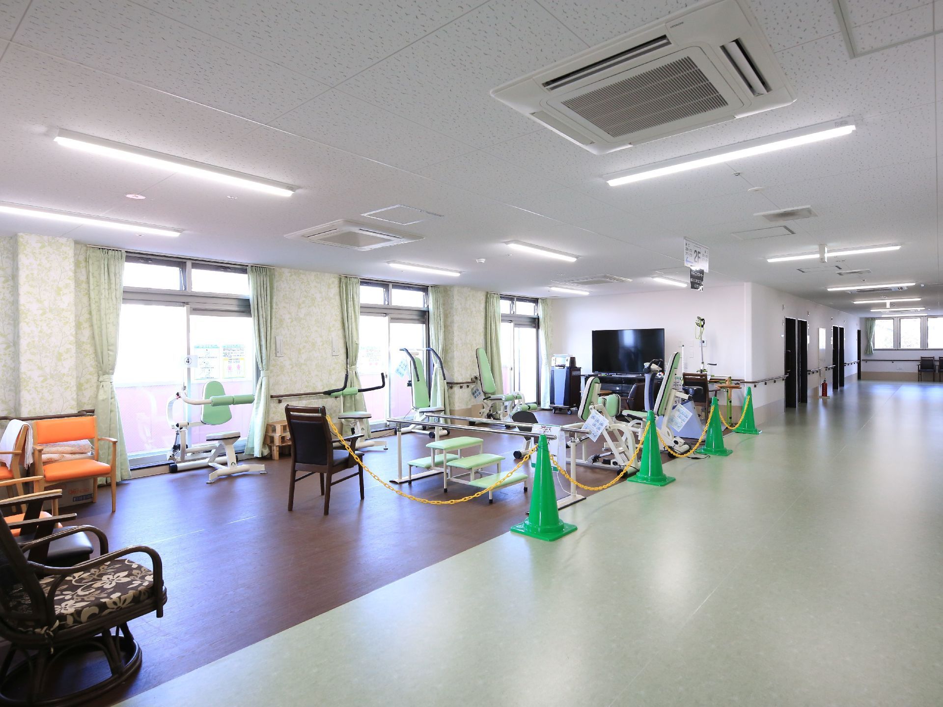 廊下の一部の場所に機能訓練室が設けられている。爽やかなグリーンの運動器具が設置されている。外の景色を見ながらトレーニングができる。