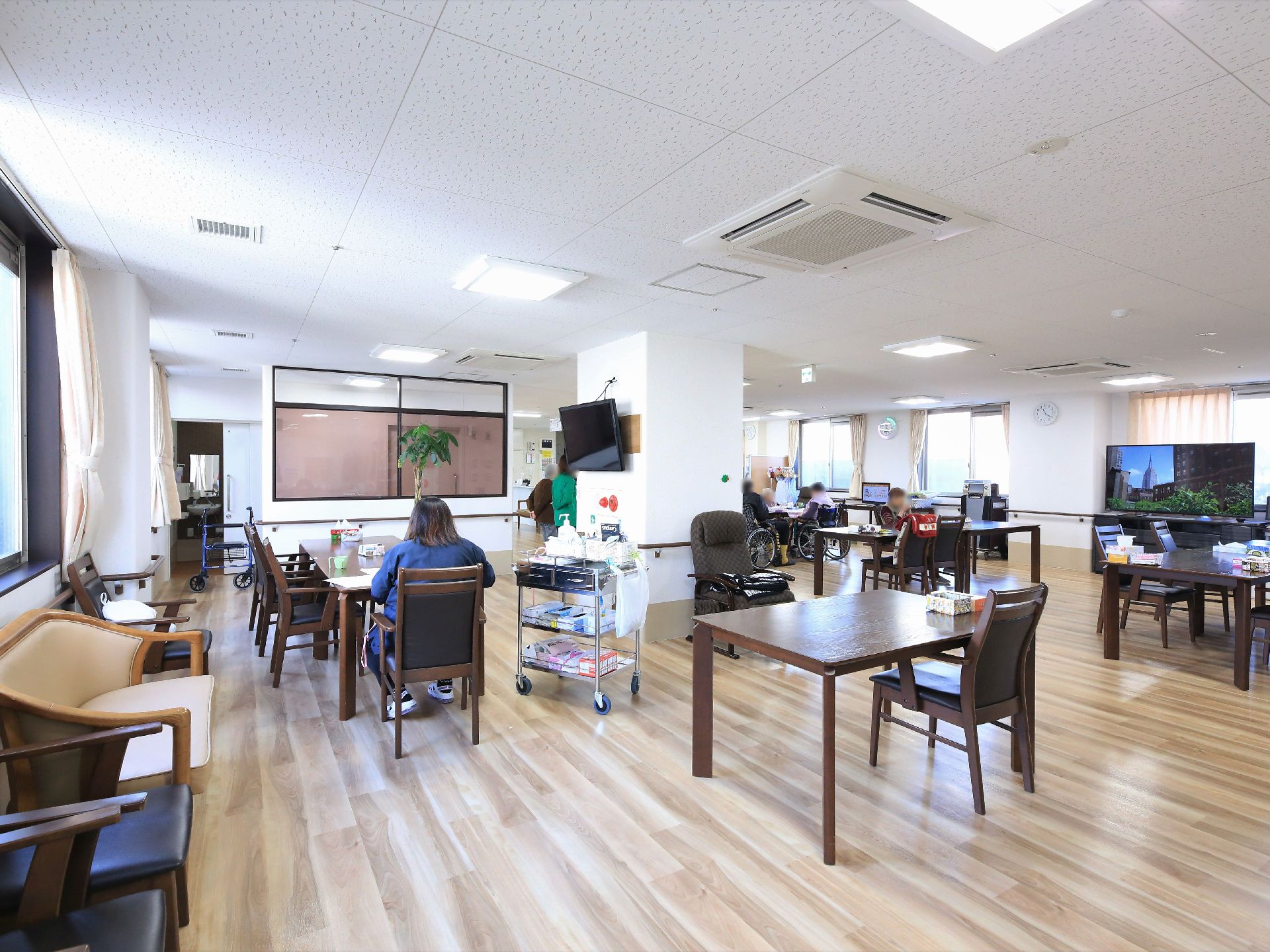 リビングにはたくさんのテーブルセットが用意されている。どの場所でもテレビが見られるように数台置かれている。窓際にベンチも置かれている。