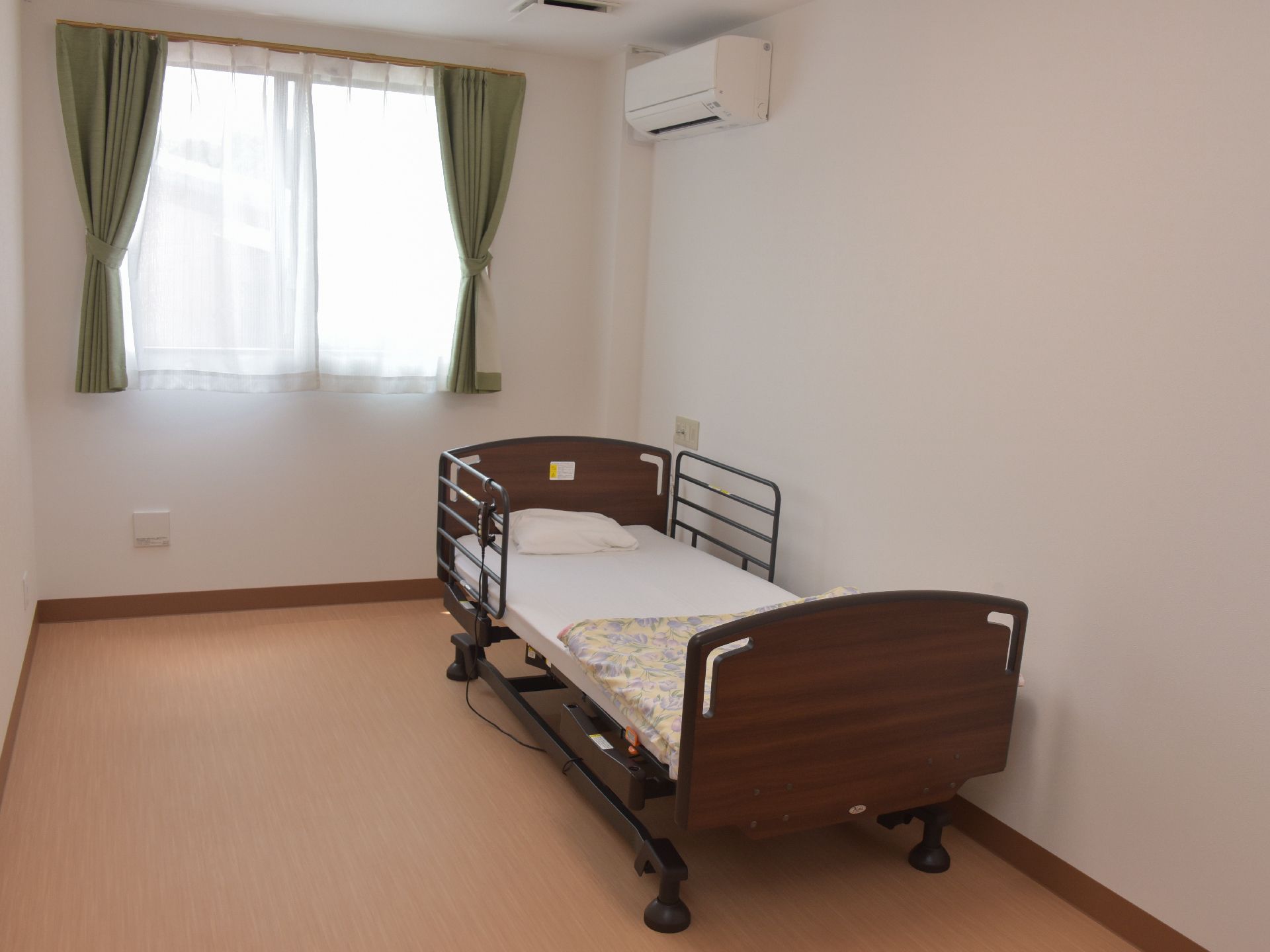 高齢者が入居する部屋には、電動の介護ベッドが設置されている。またエアコンも最初から備え付けられている。