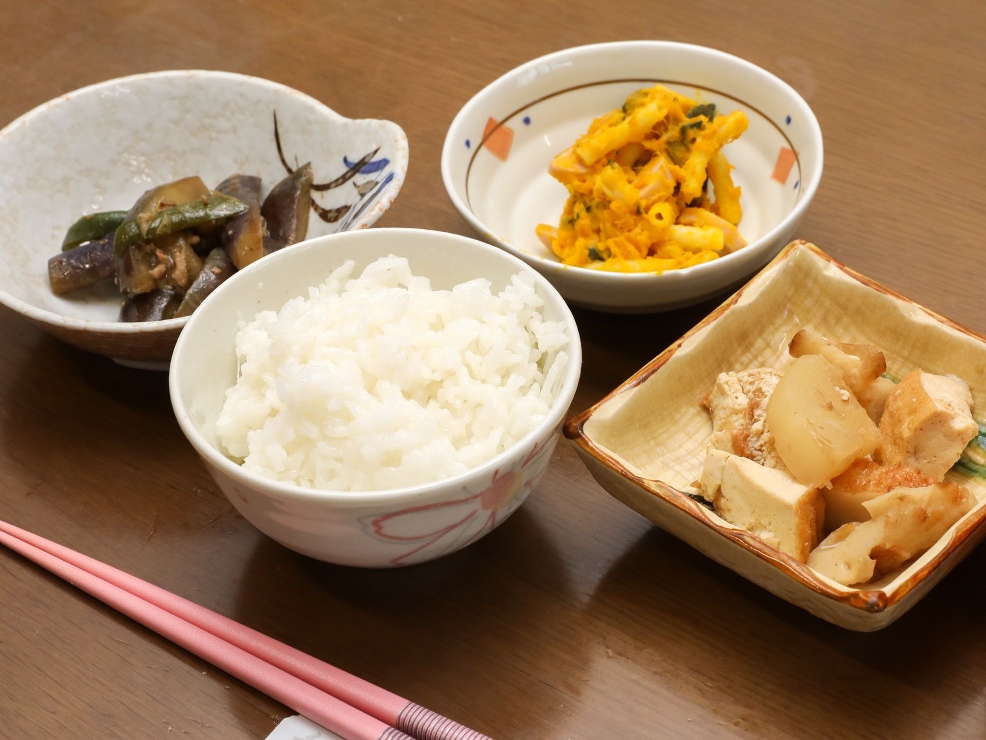食事の一例の写真。家庭的な雰囲気あふれる料理で、テーブルの上に白いご飯と野菜の入ったおかずが３品置かれている。