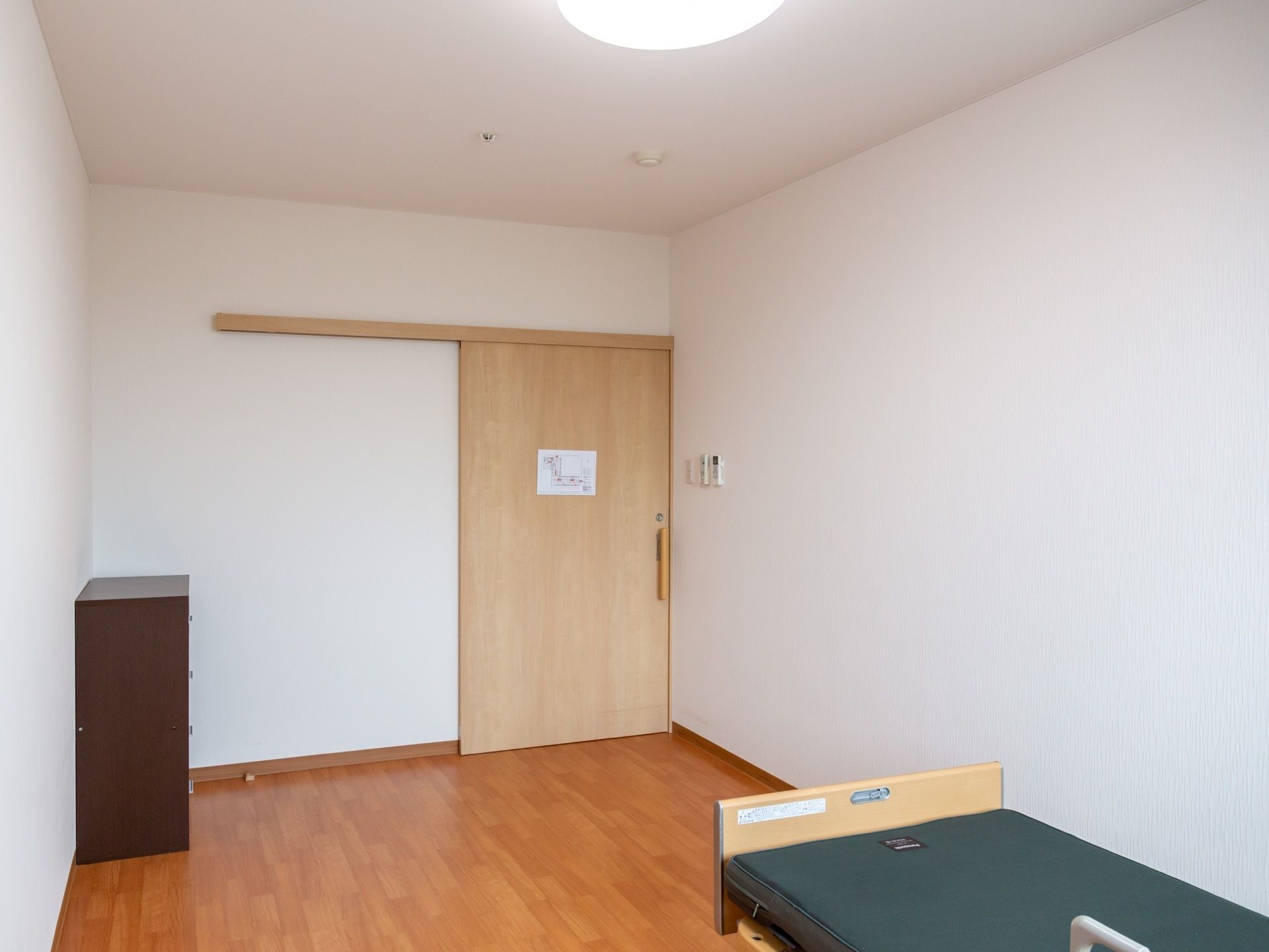 居室の出入口は木製で軽量のスライドドアになっている。入居者様は軽い力でスムーズに開閉することができ便利である。