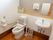 明るいトイレの便器には弾力性のある背もたれが設置されている。入居者様は使用時に安心して腰を掛けることができる。
