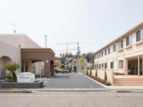 ピンクベージュ色の外壁が特徴の当施設は複数の建物から成っている。館内の窓からは外の景色を眺めることができる。
