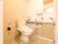とてもきれいで広さのあるトイレである。木目のカウンターがあり、手洗い場が付いている。ペーパータオルが備わっている。