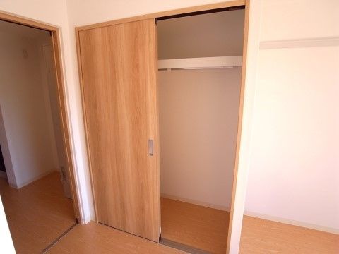居室には収納庫を備えている。木目調の引き戸を採用し、内部のメインスペースは広々とした空間で上部に棚を設置している。