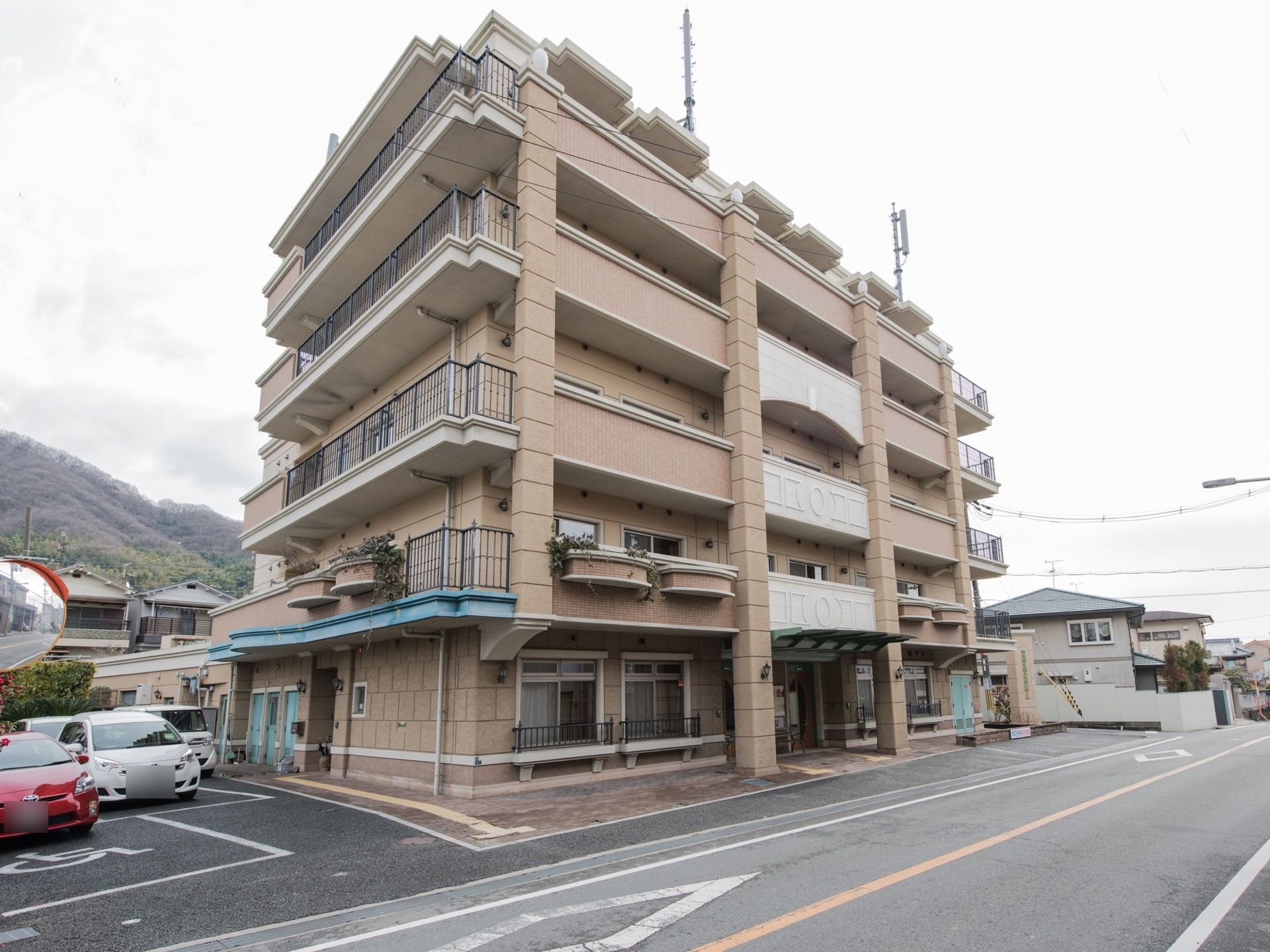施設は5階建てになっており、ブラウンが基調の落ち着いた雰囲気になっている。高級感があり、鉢植えの花がベランダに飾られている。