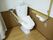 フローリングの床の上に、洋式トイレが設置され、ひじ掛けが追加されている。壁には手すりやナースコールが付いている。
