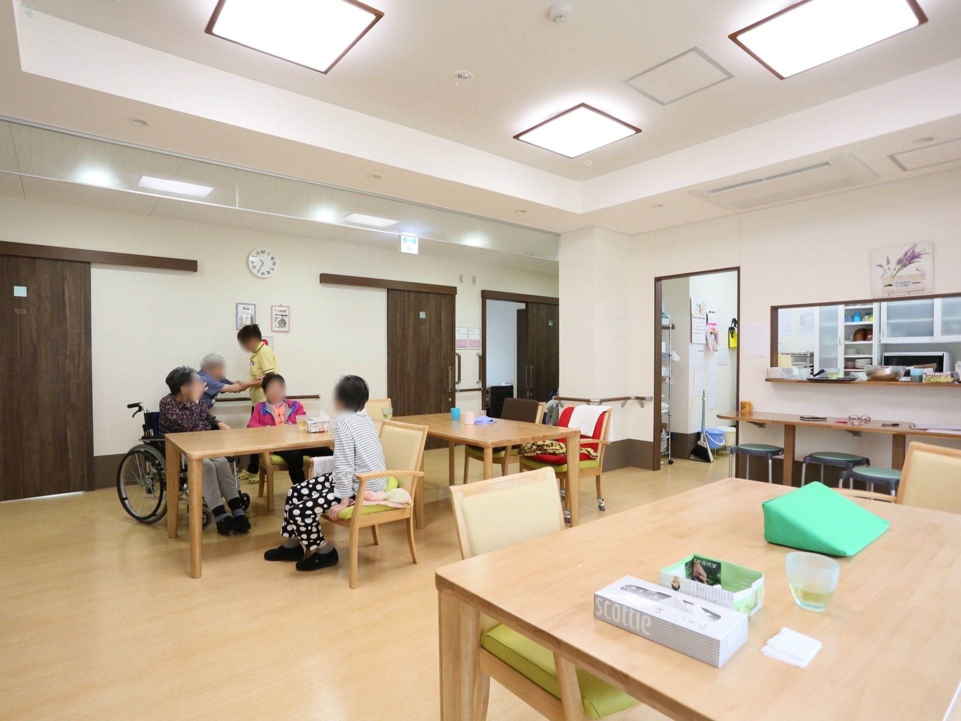 天井に四角形の照明が複数備えつけられており、部屋を明るく照らしている。壁側には濃い茶色の手すりがある。