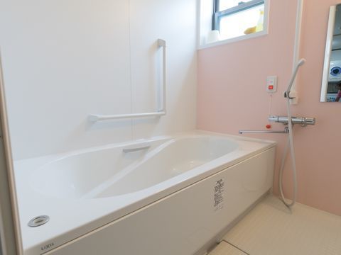 浴室の洗い場には鏡が取り付けられている。洗い場と浴槽側には縦型と横型の手すりが設置されている。呼び出しボタンもある。